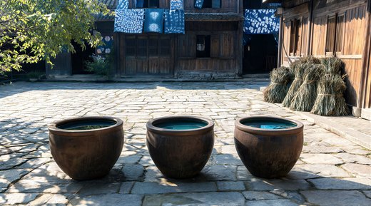 A courtyard with three dye vats